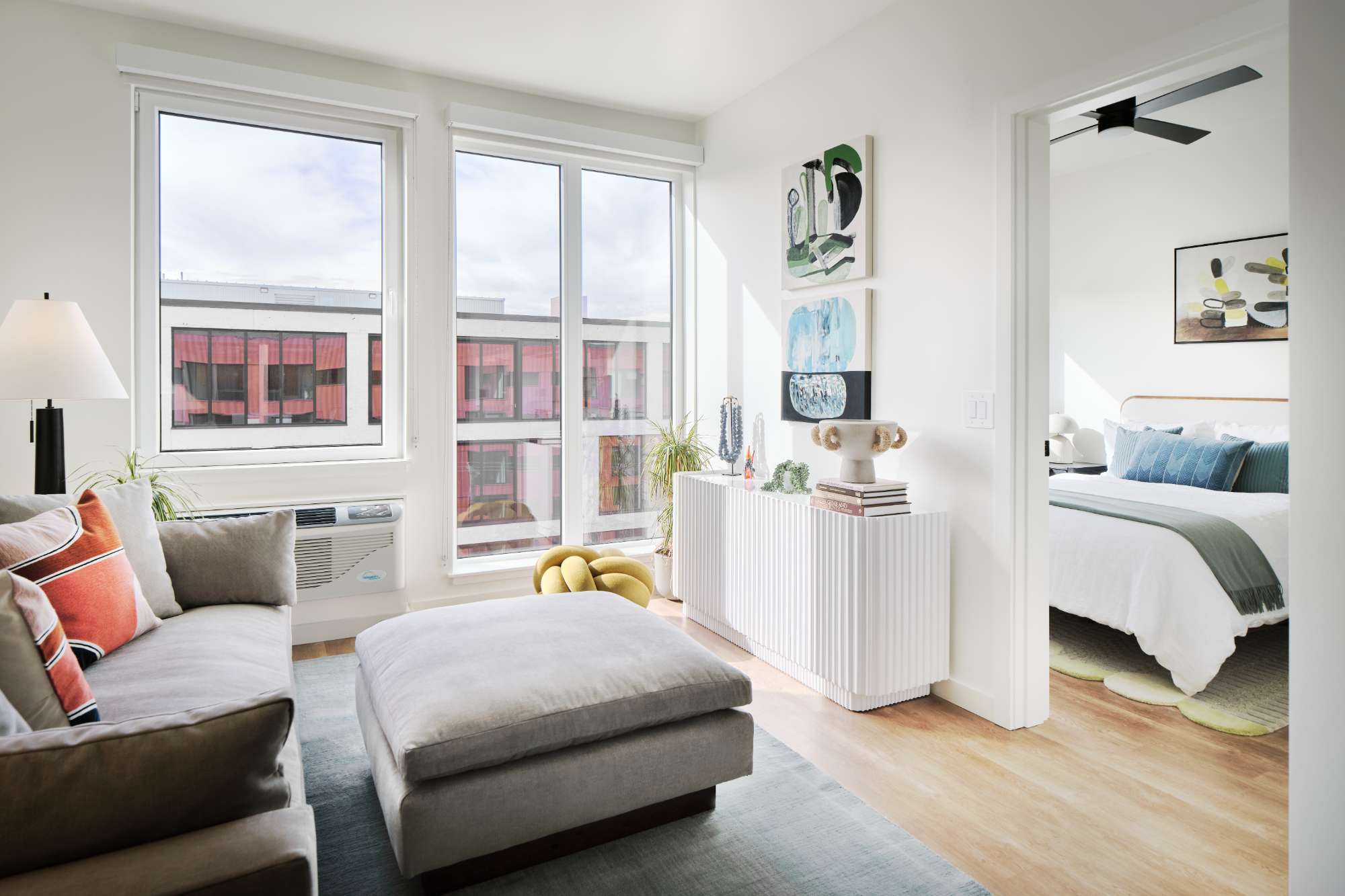 550 MLK in Portland, OR features modern apartment living rooms with large windows and updated electrical fixtures. Professional electrician services ensure well-lit spaces with floor lamps, contemporary lighting, and safe wiring throughout this stylish mixed-use development.