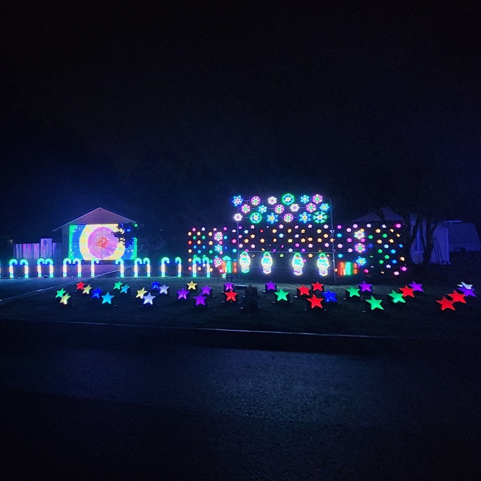 Professionally installed Christmas lights in Vancouver, WA: vibrant house and lawn displays, stars, and garage projection.