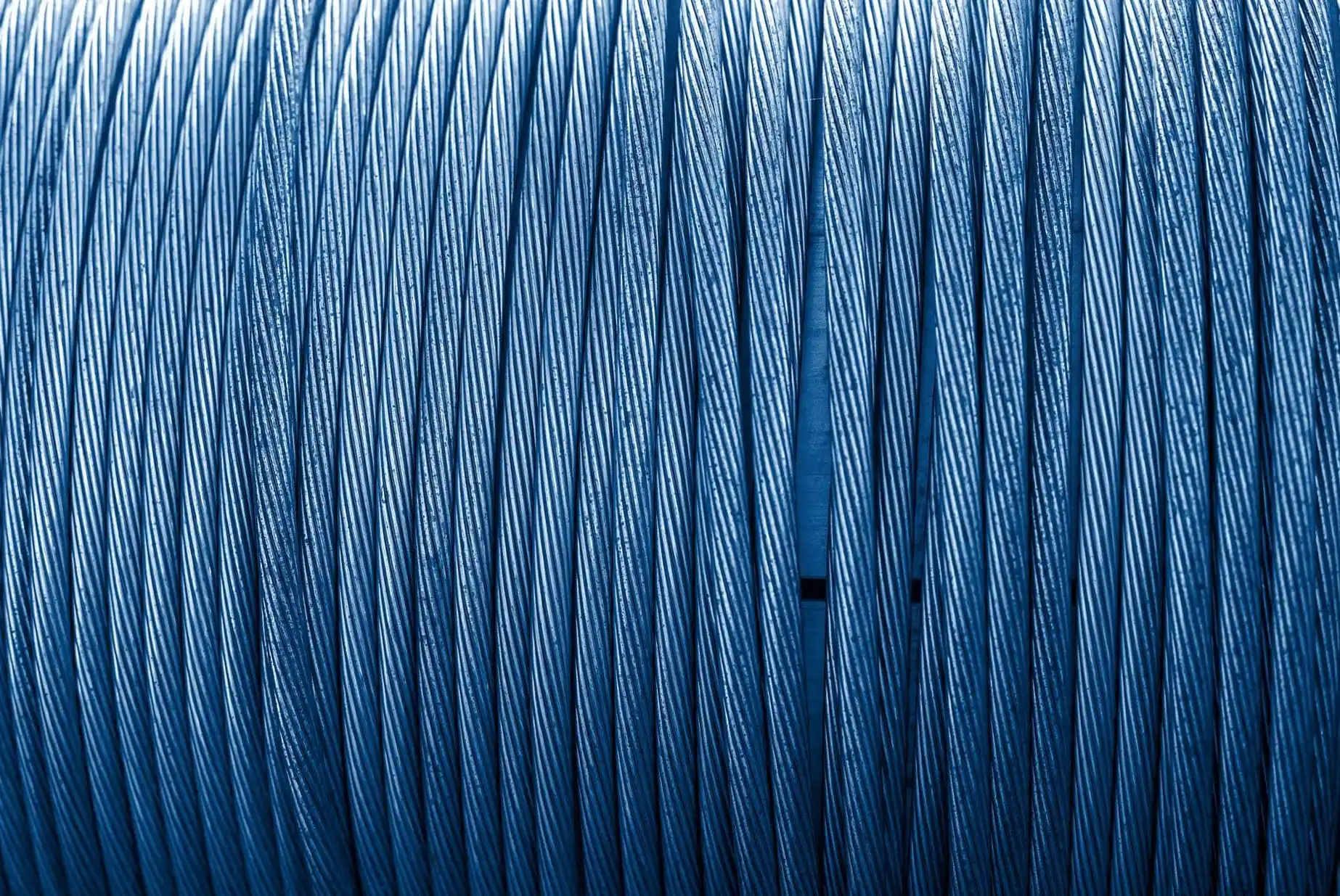 Close-up view of tightly bundled, blue metallic cables arranged vertically in parallel by a skilled Vancouver electrician.