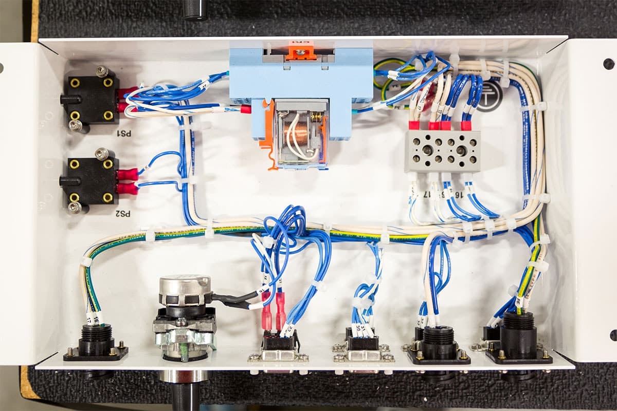 A neatly organized electrical panel with various wires, switches, and components connected inside a metal enclosure, thoughtfully crafted by a skilled electrician in Vancouver WA.