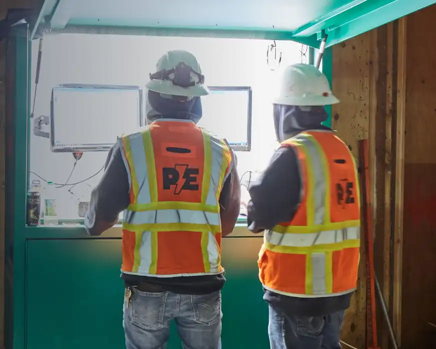 Two electricians wearing safety gear from Prairie Electric