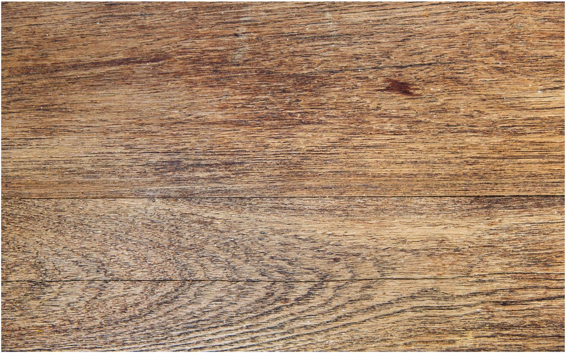 Close-up of wooden planks with a natural brown color and visible grain patterns, reminiscent of the craftsmanship an electrician in Vancouver might admire when installing fixtures in a rustic home.