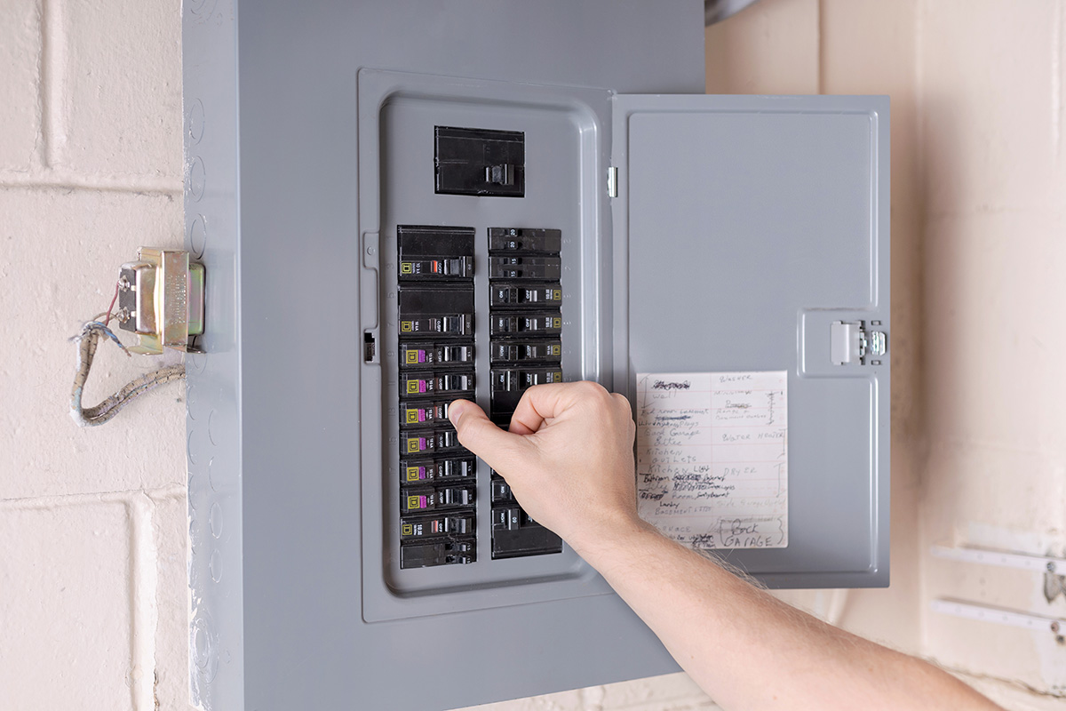 Vancouver, WA homeowner resetting a tripped circuit breaker