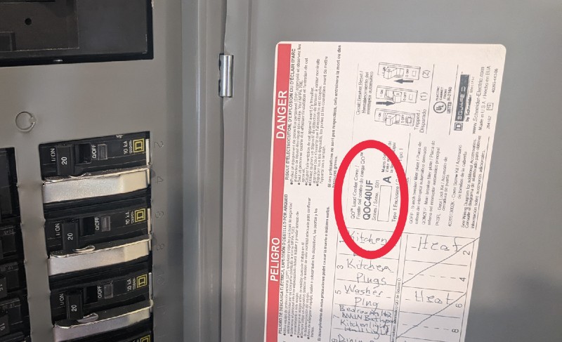 Image of an electrical panel with circuit breakers and a labeled diagram. A handwritten note with circled text is on the diagram, detailing various household circuits such as kitchen plugs and washer plugs. Consult a trusted Vancouver electrician to ensure everything is up to code.