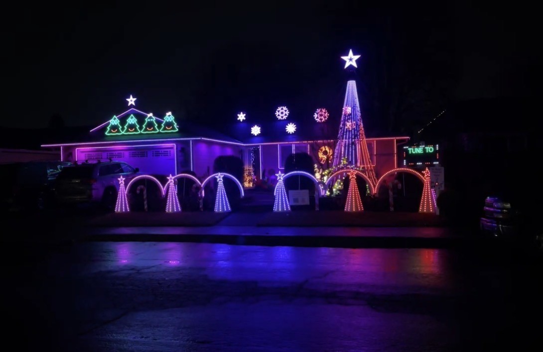 Expertly installed colorful Christmas lights illuminate a Vancouver, WA home, with arches, star tree, and glowing wreaths.
